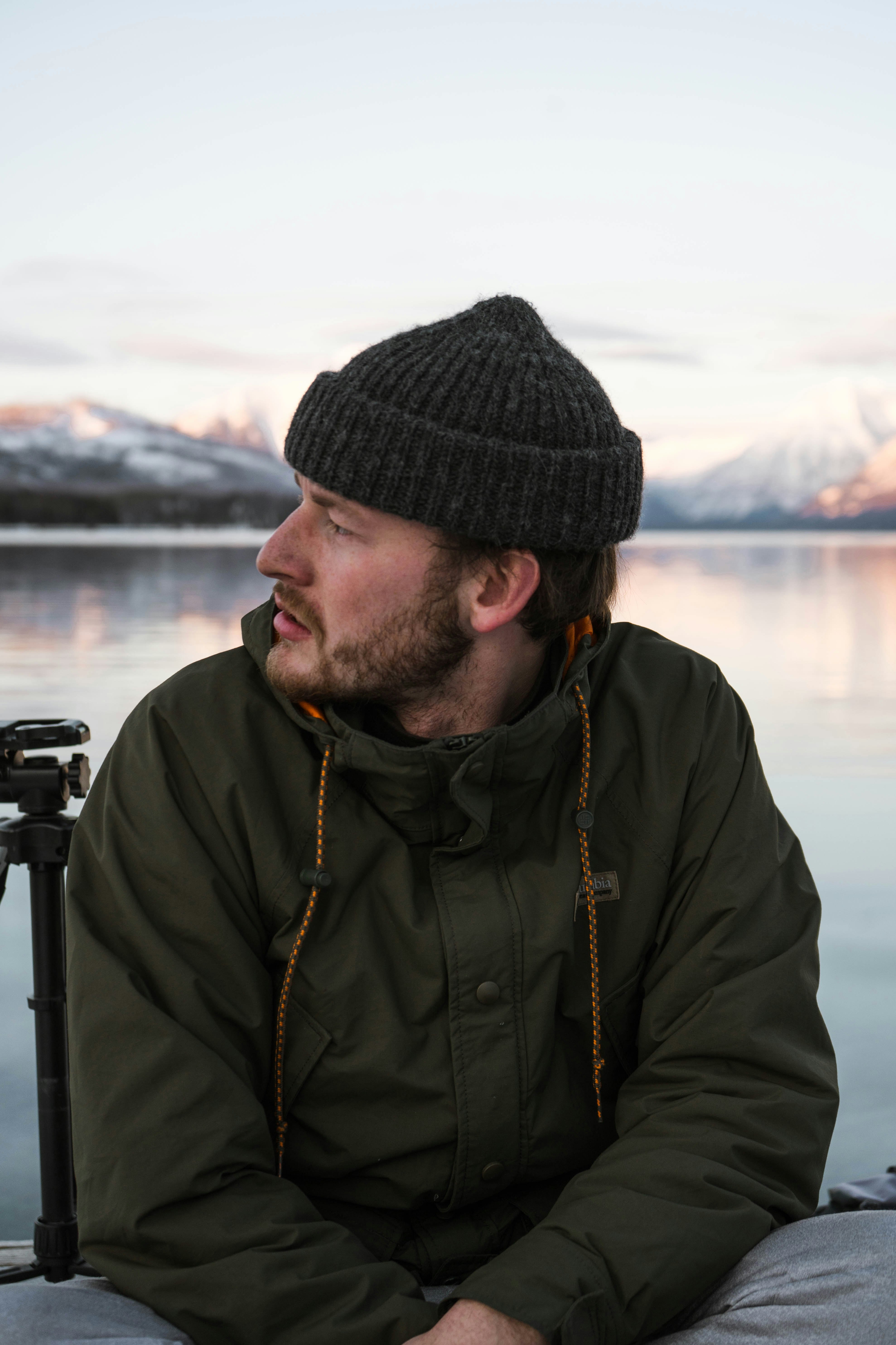 man in black knit cap and brown jacket